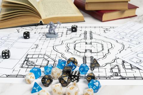 Paper map with many dice and a plastic figurine.