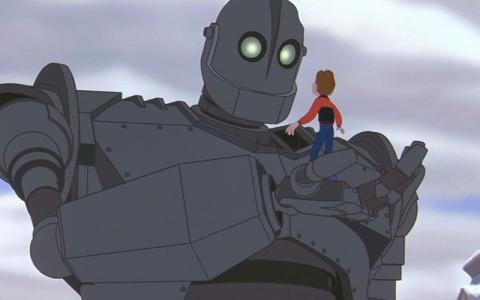 The Iron Giant from the film of the same name holding a young man on his open palm.