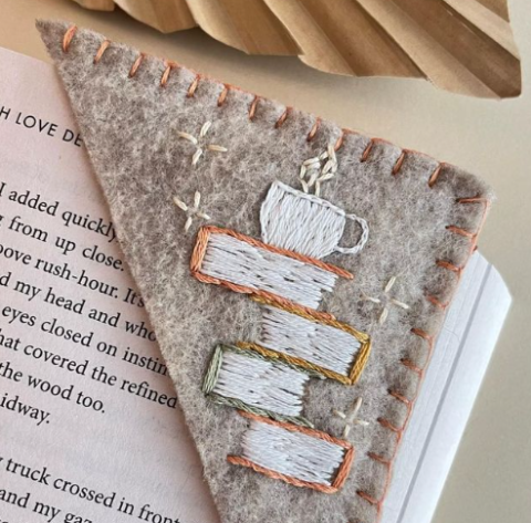 Felt corner bookmark with embroidered books, mug, and sparkles