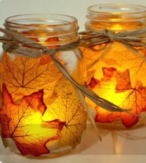 Mason jars with silk maple leaves on the outside, and candles burning on the inside