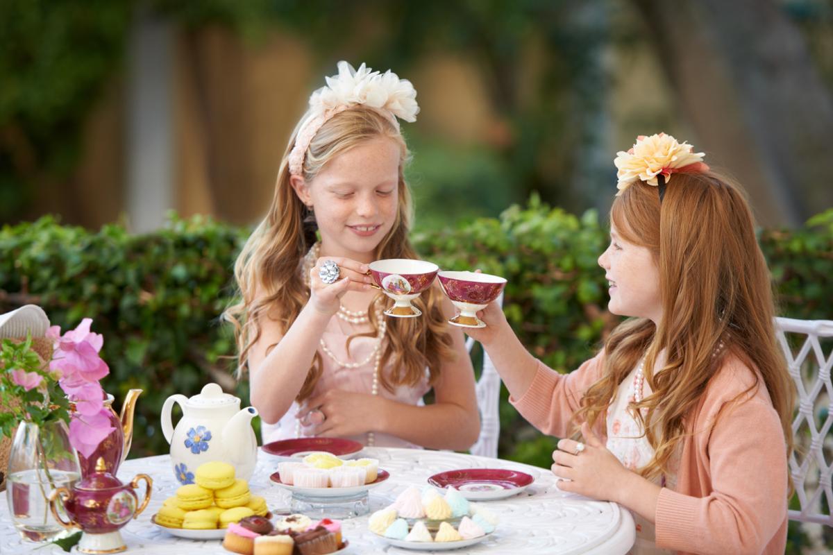 Two young ladies sitting at low tea in a garden